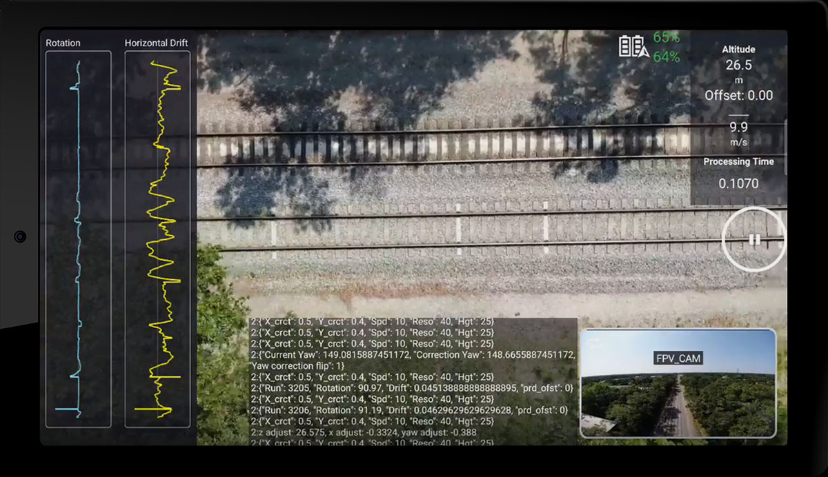 Tablet displaying a screenshot of drone autopilot software. The background of the screen shows a downward-facing video view from the drone, and various measurements and buttons are overlaid, along with a code log and a small picture-in-picture forward-facing view.